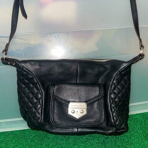 Black leather purse with lock accent and quilted sides.